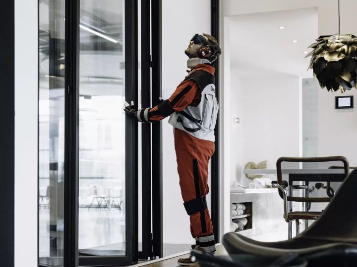 Gewichte an Beinen, Armen und Händen sowie eine spezielle Brille simulieren Alterserscheinungen. Auch unter diesen Voraussetzungen lässt sich die Glas-Faltwand von Solarlux gut bedienen.  Copyright: Solarlux GmbH