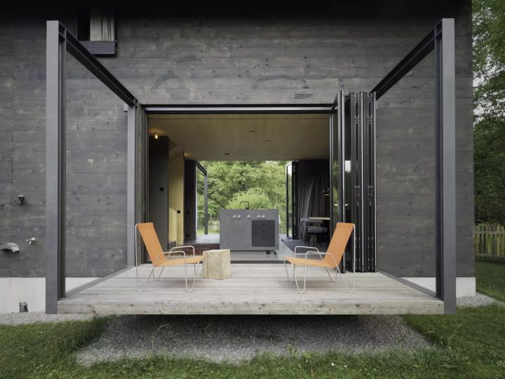 Die schwebende Terrasse wirkt wie ein Steg in die Natur. Die Glas-Faltwände verlängern diesen optisch durch das komplette Erdgeschoss bis zur gegenüberliegenden Terrasse.   Bildnachweis: Florian Holzherr