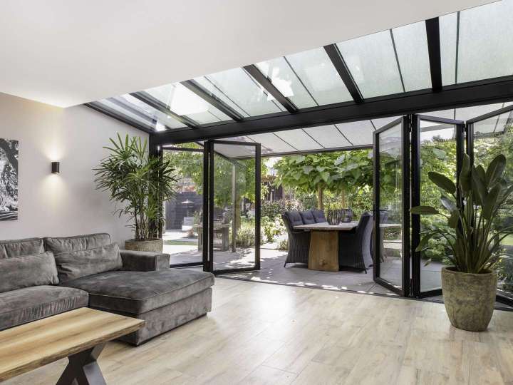 Wohnzimmer mit einem Solarlux Wintergarten mit Aufglas-Markise