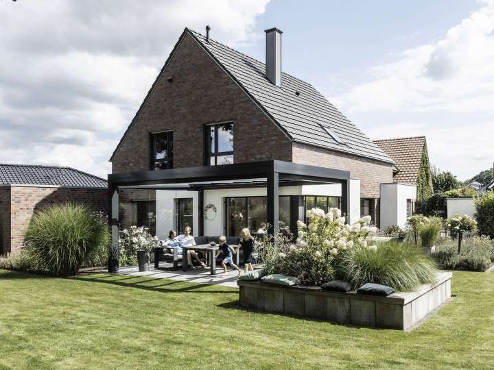 Familie unter einem SDL Acubis Terrassendach an einem Wohnhaus