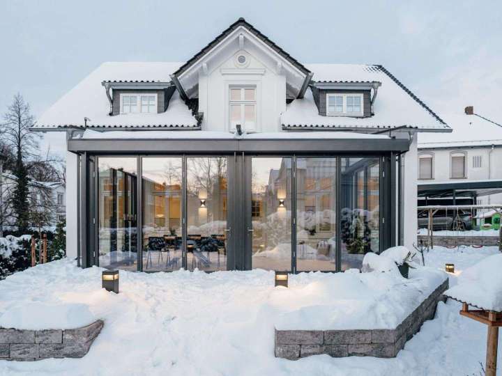 Wintergarten an einem Wohnhaus im Schnee